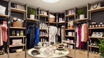 A well-organized boutique with shelves of clothing, accessories, and toiletries.