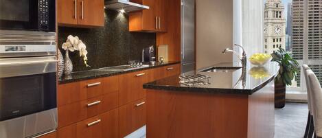 Una cocina moderna con armarios de madera, electrodomésticos de acero inoxidable y un amplio ventanal con vista panorámica de la ciudad.