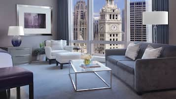 A modern hotel room with a large window, a sofa, a coffee table, and a bed.