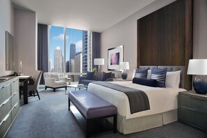 Une chambre d’hôtel moderne dotée d’un grand lit, d’un bureau, d’une chaise et offrant une vue sur le panorama urbain.