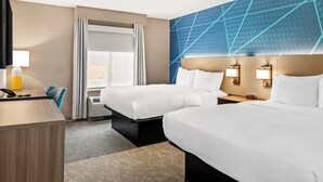 A hotel room with two beds, a desk, a chair, a TV, and a large wall with geometric patterns. - Comfort Inn Emporia (Emporia)