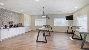 A modern kitchen with white cabinets, a countertop with various items, and three pendant lights. - Extended Stay America Suites - Baytown (Baytown)