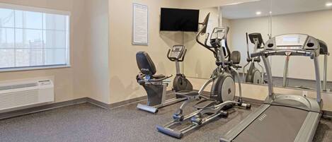 A fitness center with a treadmill, elliptical, and stationary bike.