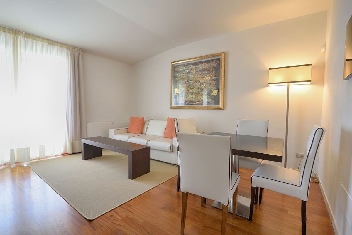 Una sala moderna con sofá, mesa de centro y comedor.