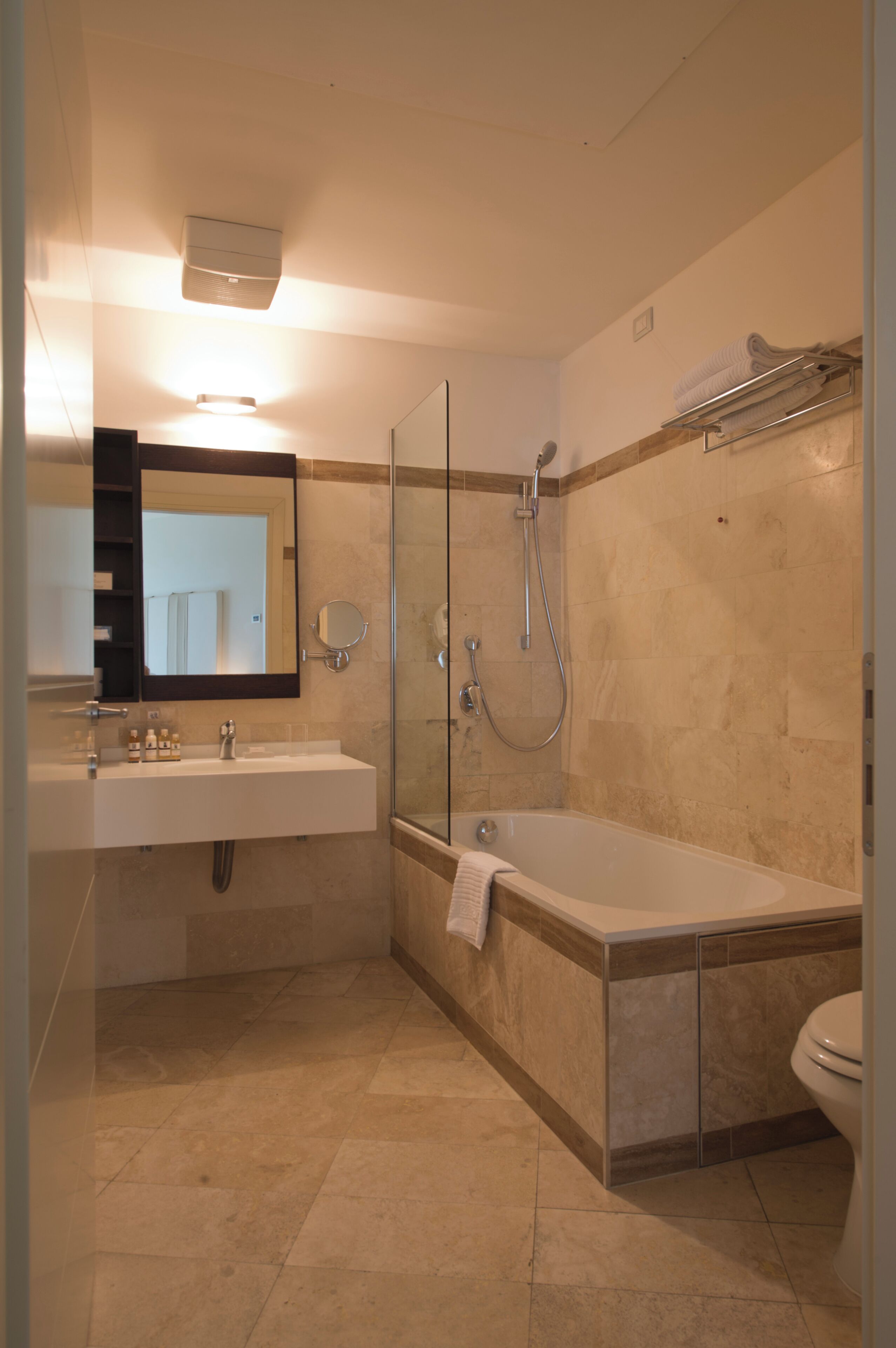 Un baño moderno con ducha de vidrio, bañera independiente y tocador con espejo.