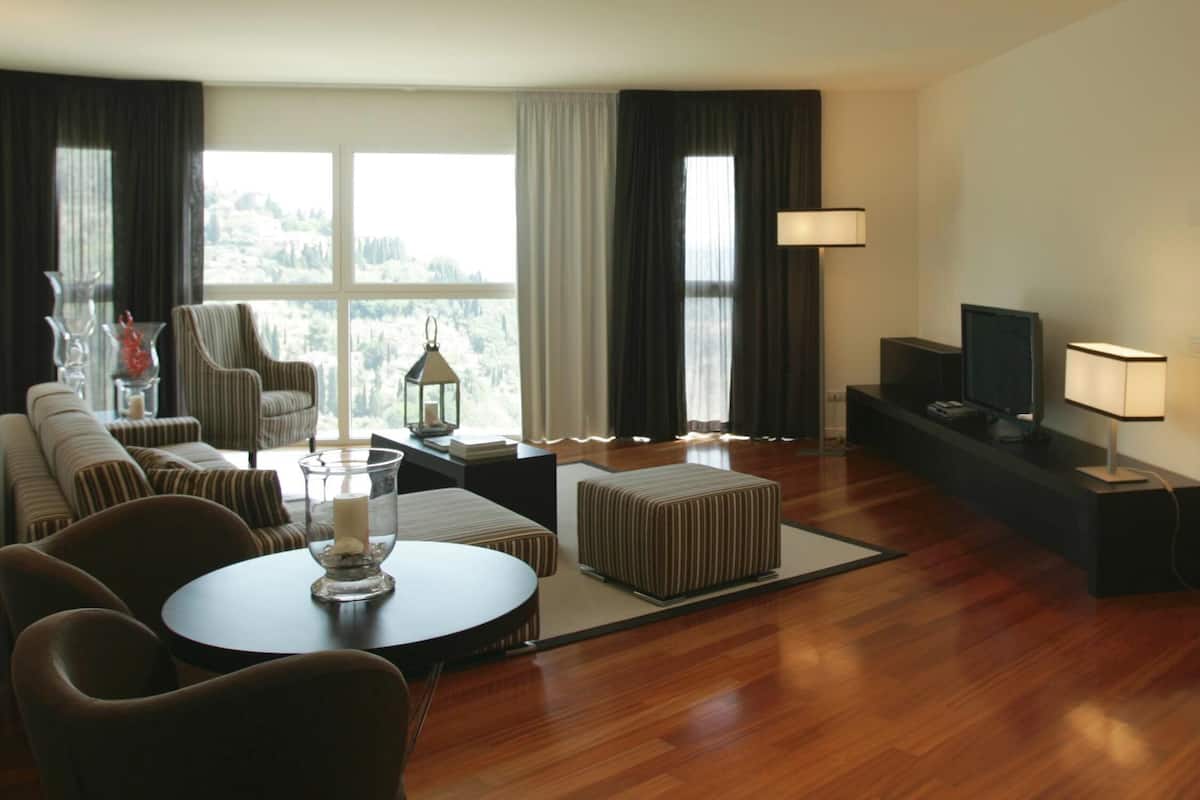 Una sala de estar moderna con un sofá, sillones, una mesa de centro y un televisor.