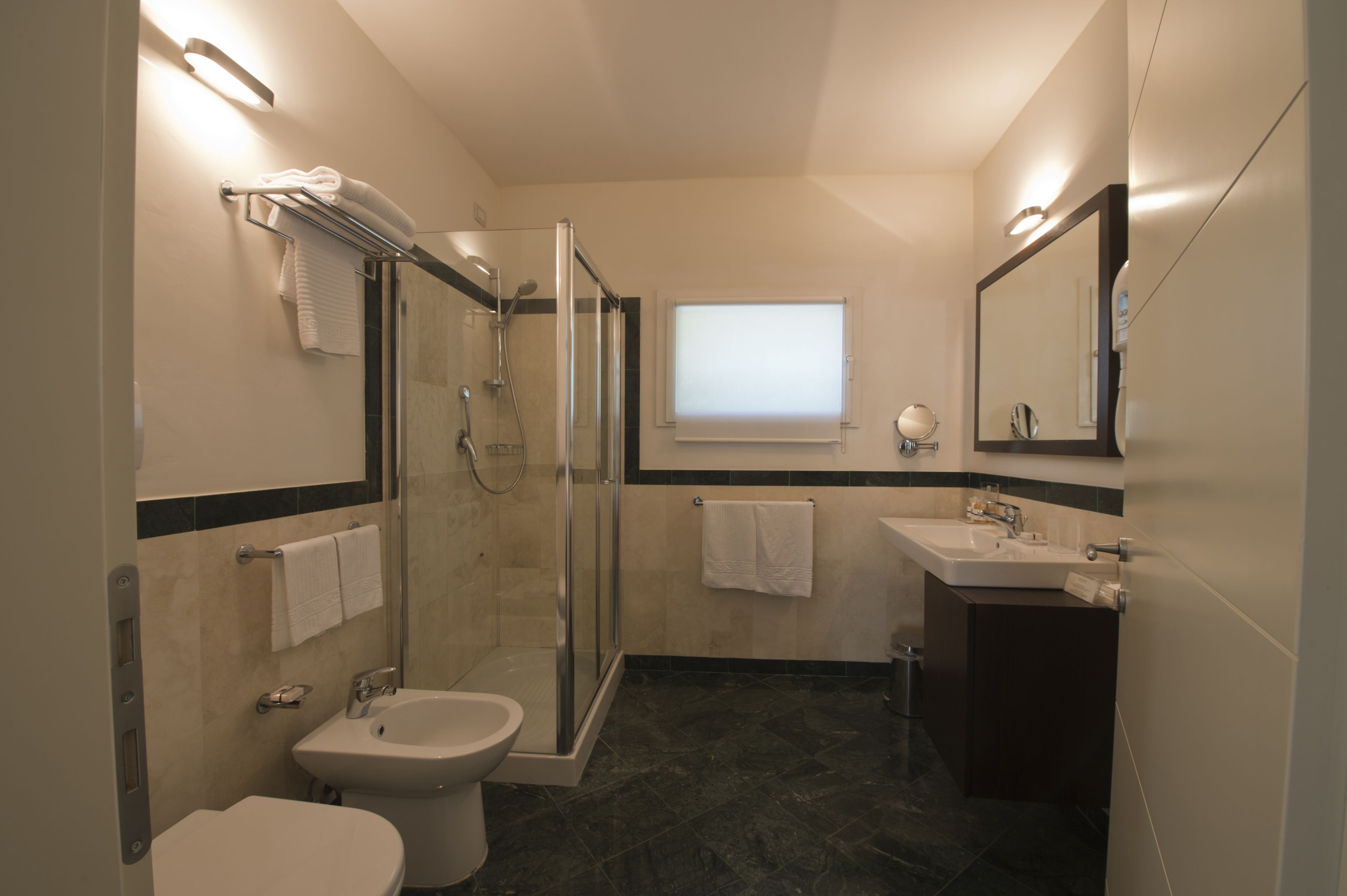 A modern bathroom with a glass-enclosed shower, a sink, and a toilet.