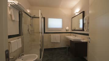 A modern bathroom with a glass-enclosed shower, a sink, and a bidet.