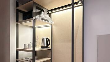 Une chambre moderne et compacte, dotée d’étagères intégrées et d’une armoire pliante.