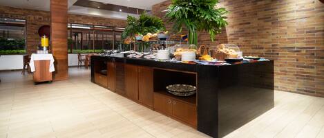 Un espace buffet moderne avec un comptoir en bois, une variété de plats et des plantes en pot.