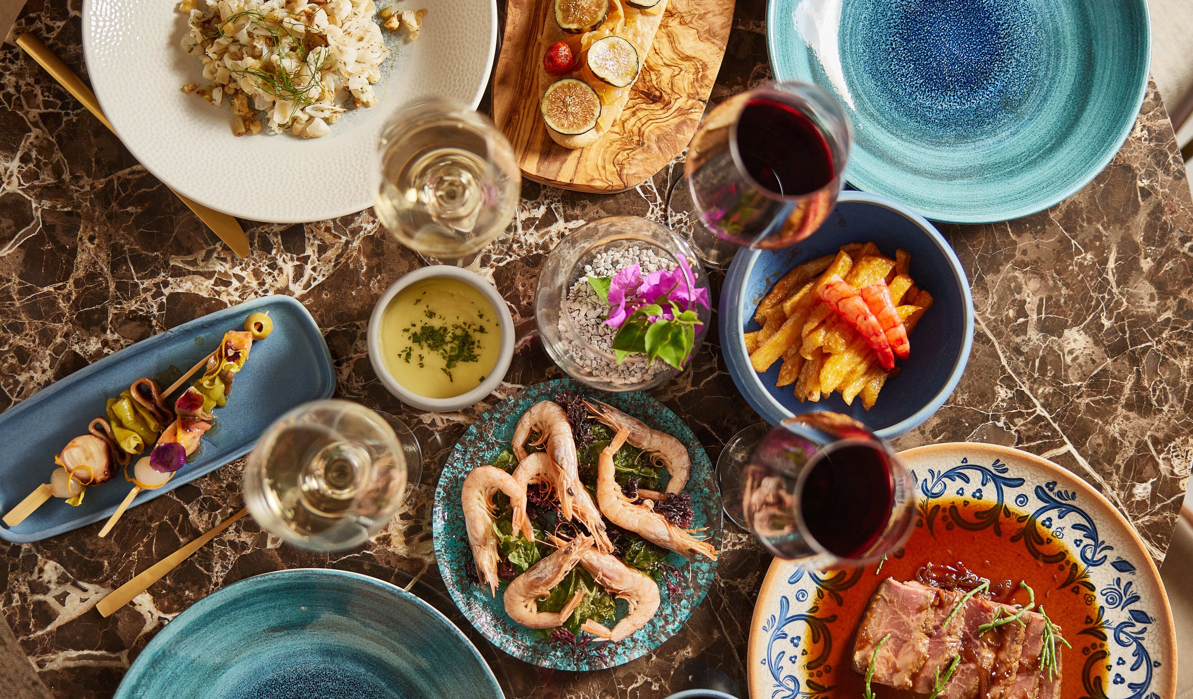 Diversos platos y bebidas sobre una mesa de mármol.