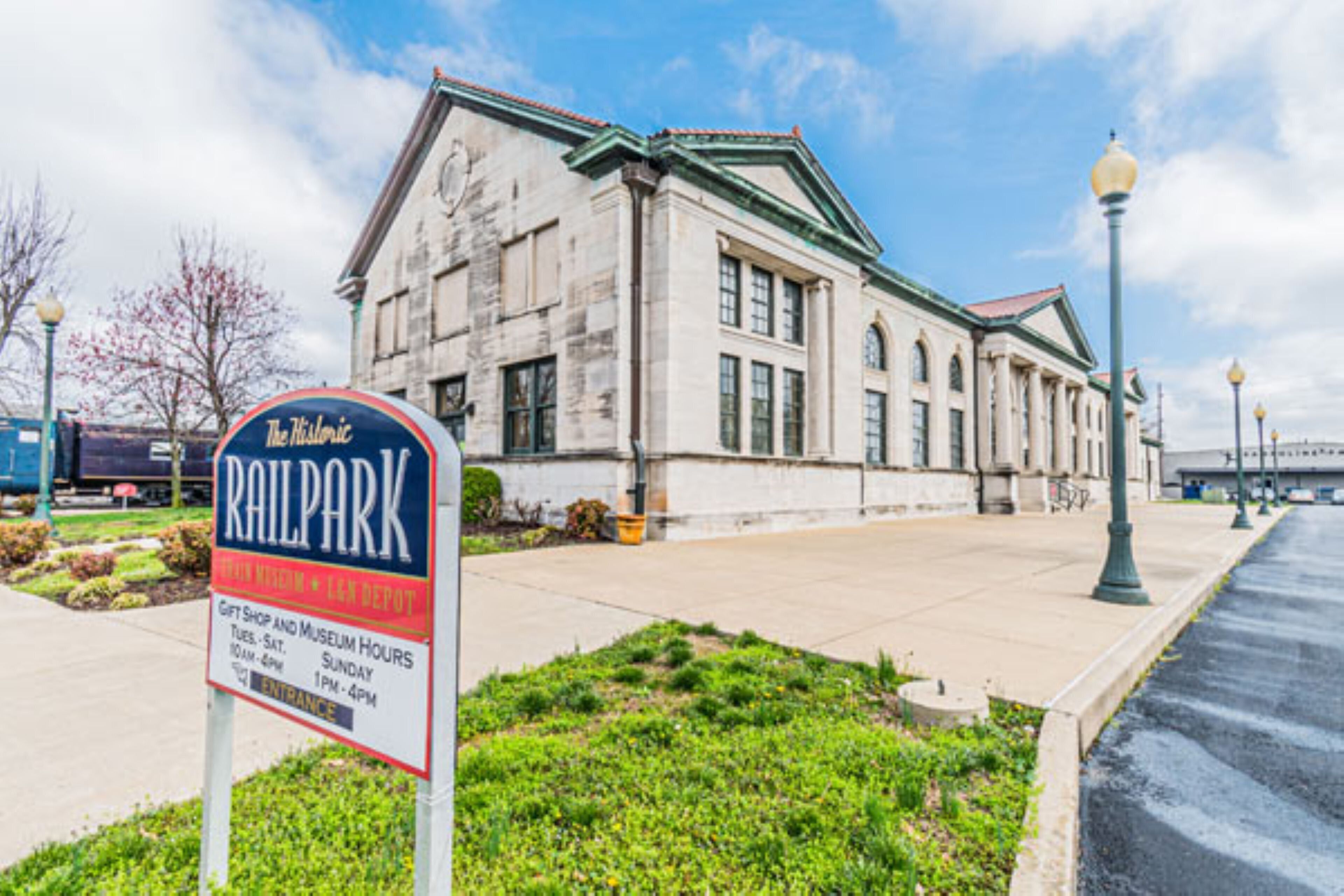A historic building with a sign for The Historic Railpark, gift shop, and museum hours.