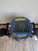 Una máquina de videojuegos clásica con pantalla de puntaje, botones y un joystick.