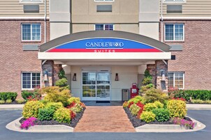 Entrada de un hotel con un cartel que dice 'CANDLEWOOD SUITES'.