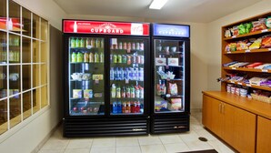 A kitchenette area with two beverage dispensers labeled 'Candlewood Cupboard' and 'Coca-Cola'.