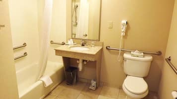 A bathroom with a bathtub, toilet, sink, and a hand dryer.