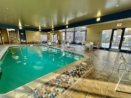 Una piscina techada, sillones reclinables de piscina