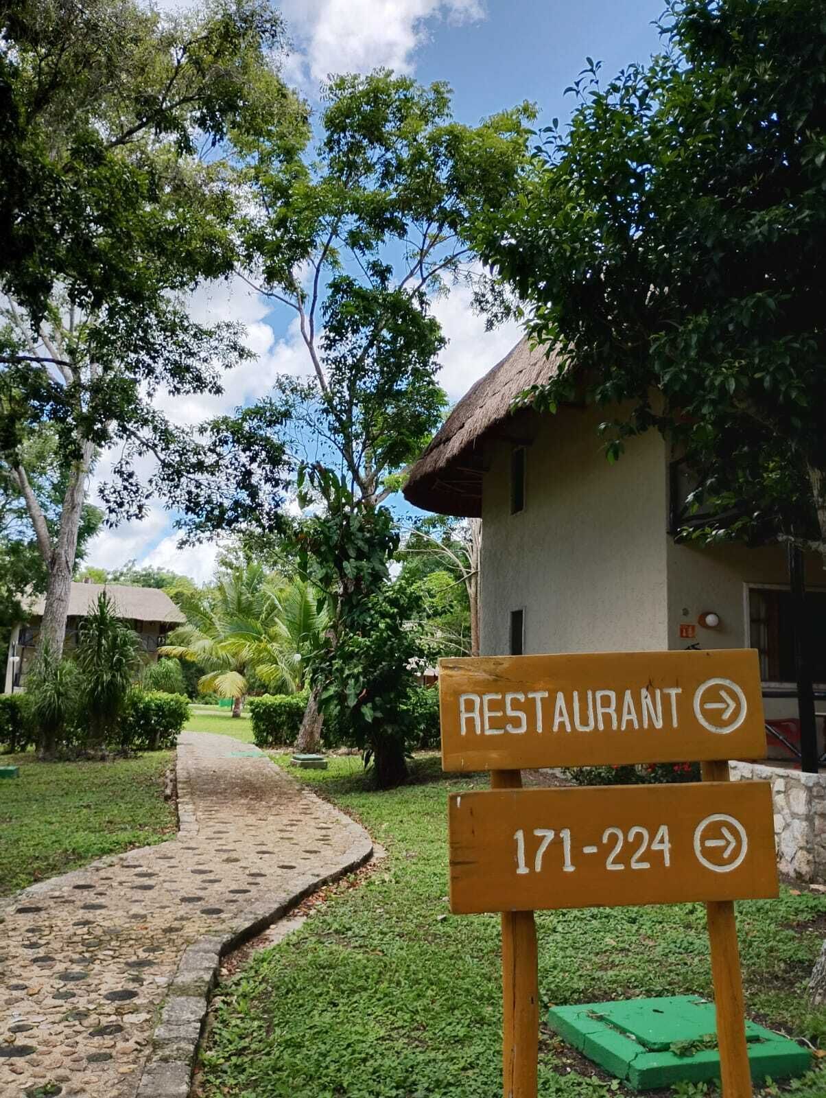 Ein Weg führt zu einem Gebäude, an dem ein Schild für ein Restaurant zu sehen ist.