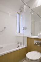 Un bagno moderno con vasca, servizi igienici e cabina doccia in vetro.