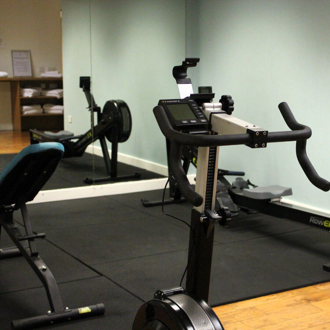 Un gimnasio con bicicletas estáticas y una cinta de correr.