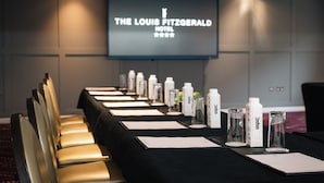 A conference room at The Louis Fitzgerald Hotel with a long table set for a meeting, equipped with water bottles and glasses. - The Louis Fitzgerald Hotel (Dublin)