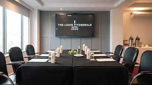 A conference room at The Louis Fitzgerald Hotel with a large screen displaying the hotel name and a four-star rating. - The Louis Fitzgerald Hotel (Dublin)