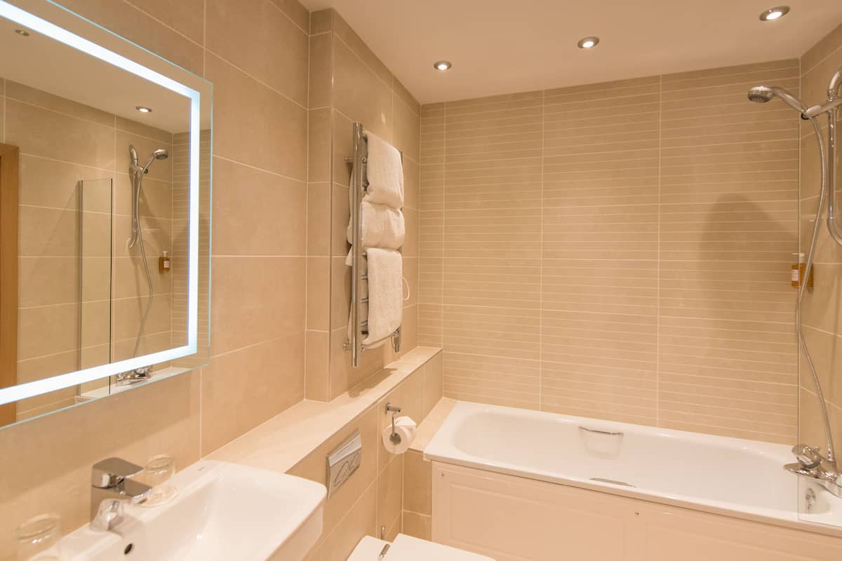 combined shower/bathtub, designer toiletries, hair dryer, towels