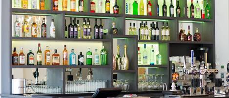 A bar area with shelves of various liquor bottles and a tap bar with multiple beer taps.
