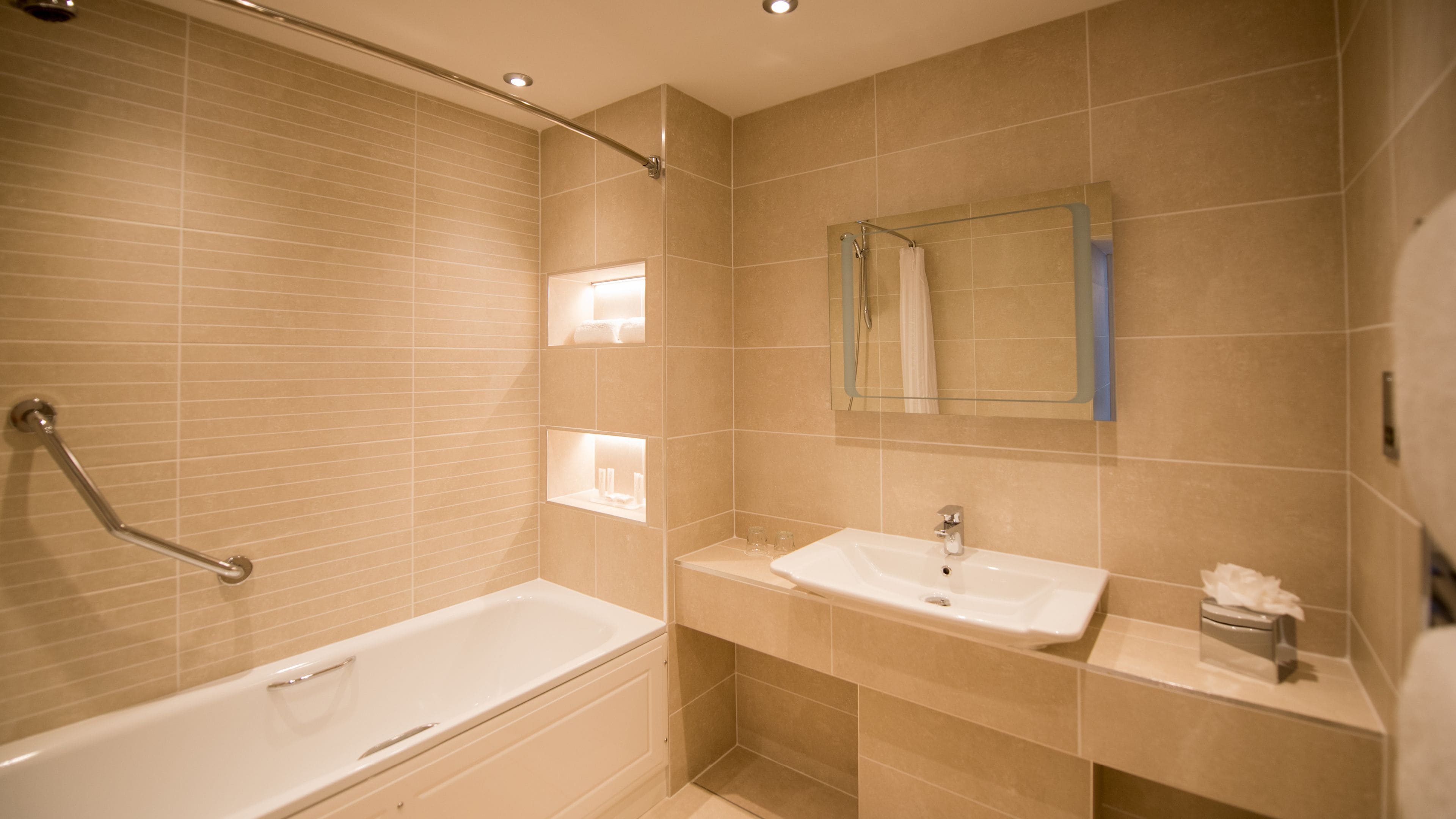 A modern bathroom with a bathtub, a sink, and a shower.