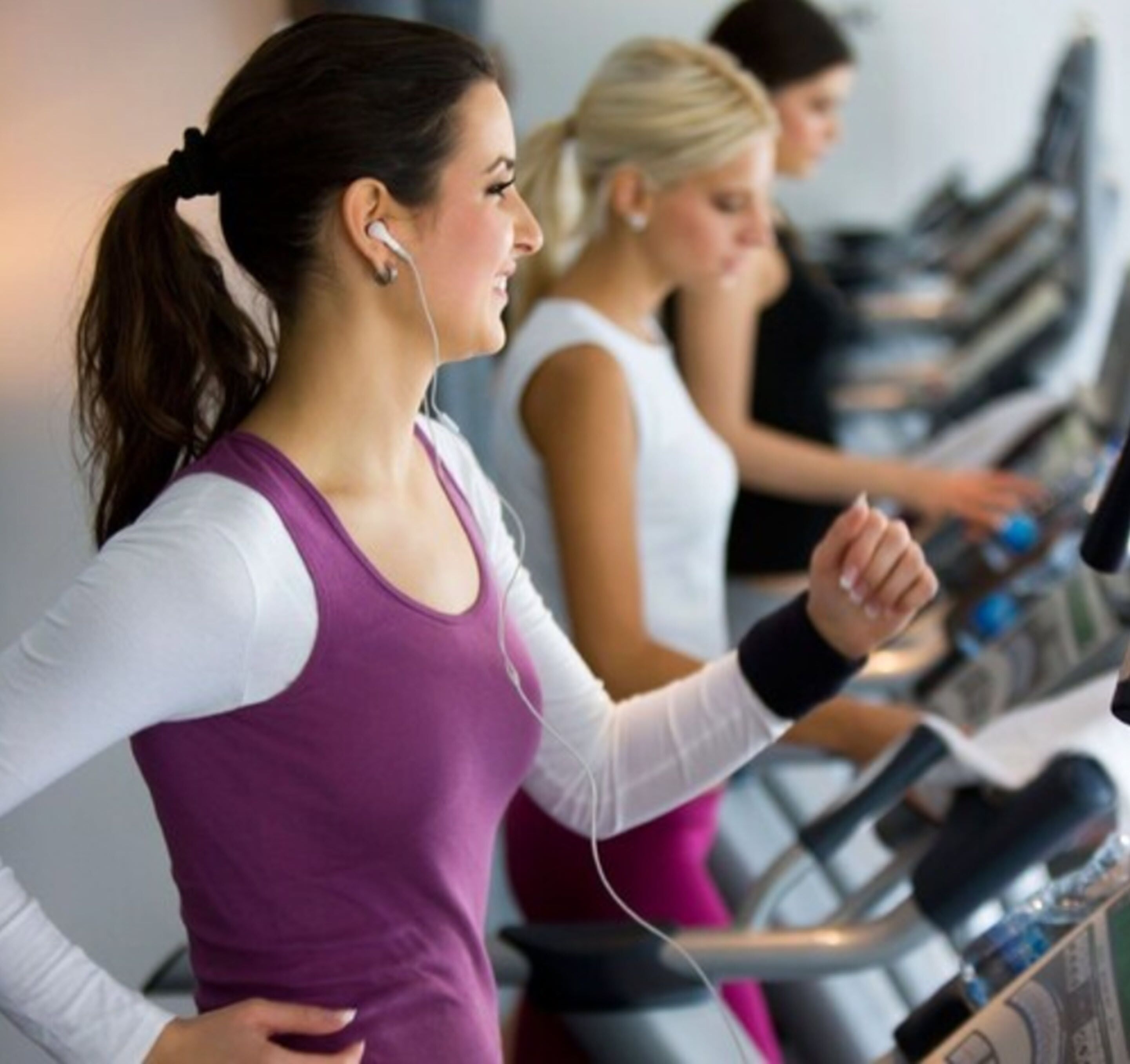 A gym with treadmills and a person using one.