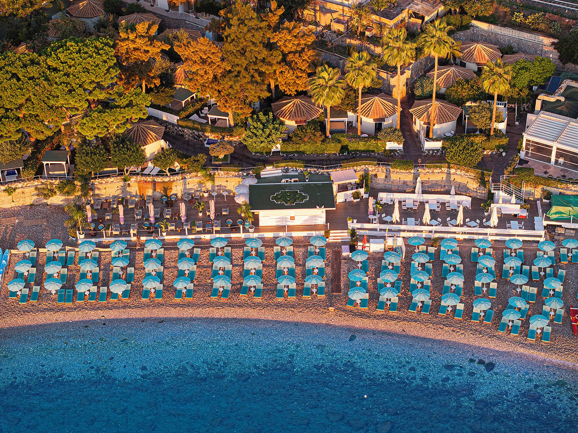 Privatstrand, schwarzer Sandstrand, Liegestühle, Sonnenschirme