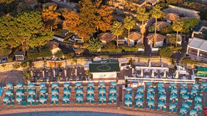 An aerial view of a resort with multiple swimming pools, beachside seating, and a variety of villas and bungalows. - La Plage Resort (Taormina)