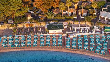 Privatstrand, schwarzer Sandstrand, LiegestĂŒhle, Sonnenschirme