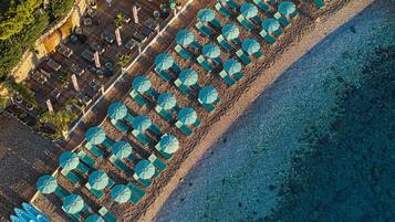 Privatstrand, schwarzer Sandstrand, Liegestühle, Sonnenschirme