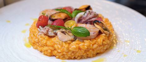 Un plato de risotto con mariscos y verduras.
