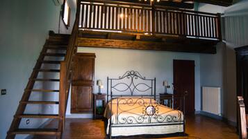 A bedroom with a wooden staircase, a metal bed frame, and a wooden door.