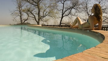Piscina a l'aire lliure, para-sols i gandules