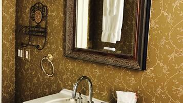 Une salle de bain avec un lavabo blanc, un miroir et une serviette suspendue à un porte-serviettes.