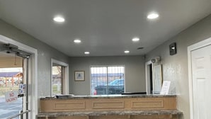 A reception area with a counter, a door, and a window. - Regency Inn Hondo (Hondo)