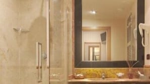 A modern bathroom with a glass shower enclosure, a sink with a mirror, and a vanity area. - ResidenzaRomaCentro (Rome)