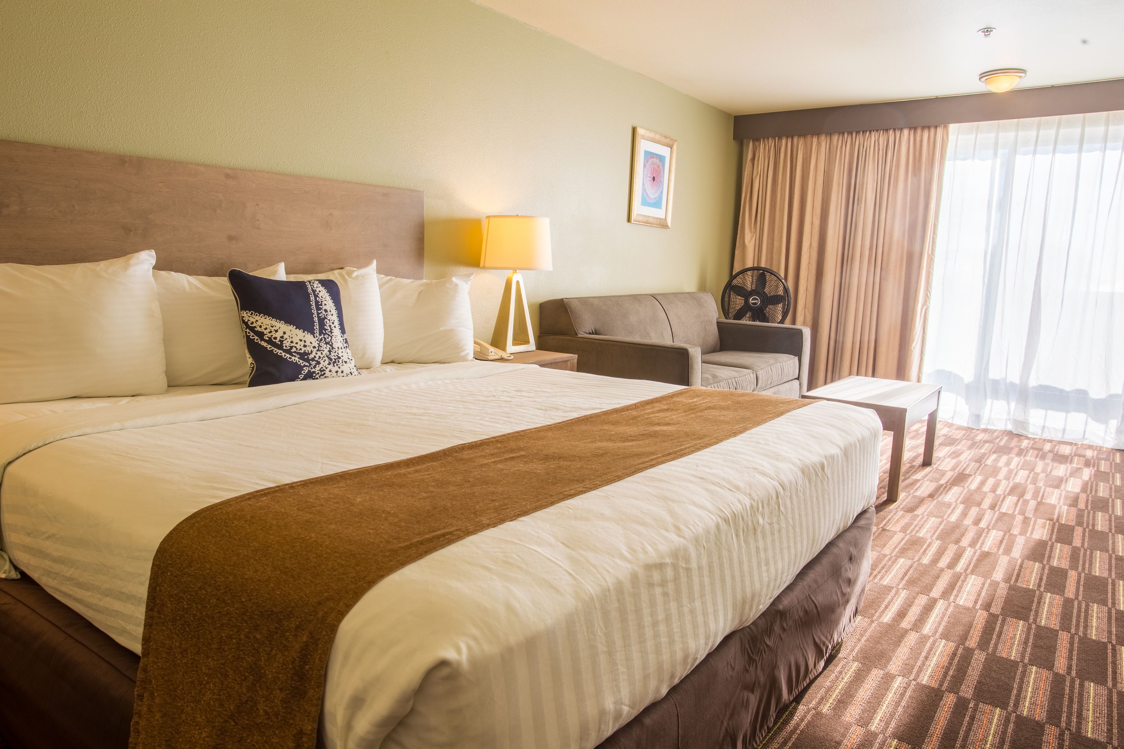 Een hotelkamer met een groot bed, een bank, een bureau en een stoel.