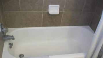 Eine Badewanne mit Wasserhahn und einer Seifenschale an der Wand.