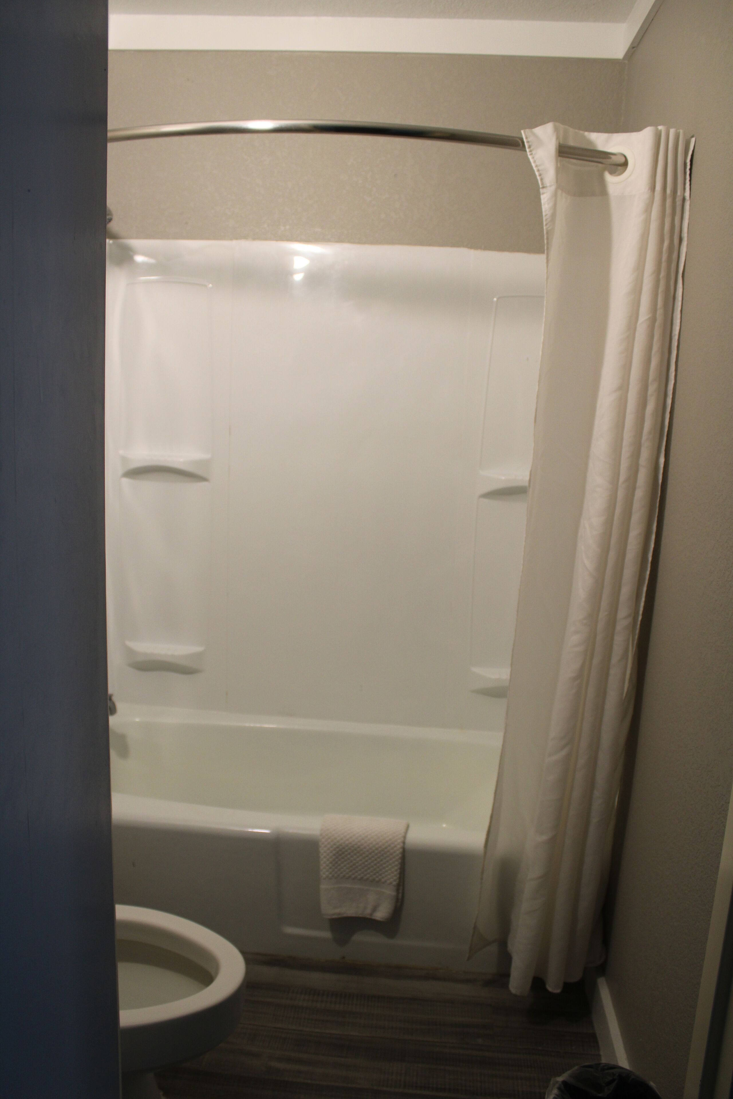 A bathroom with a bathtub, toilet, and shower curtain.