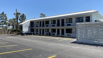 Un motel composé d’un bâtiment à deux étages, doté de plusieurs balcons et d’un parking.