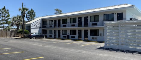 Un motel composé d’un bâtiment à deux étages, doté de plusieurs balcons et d’un parking.