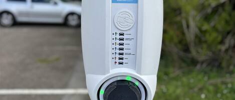 An EVBOX charging station with a QR code, contact information, and status indicators.