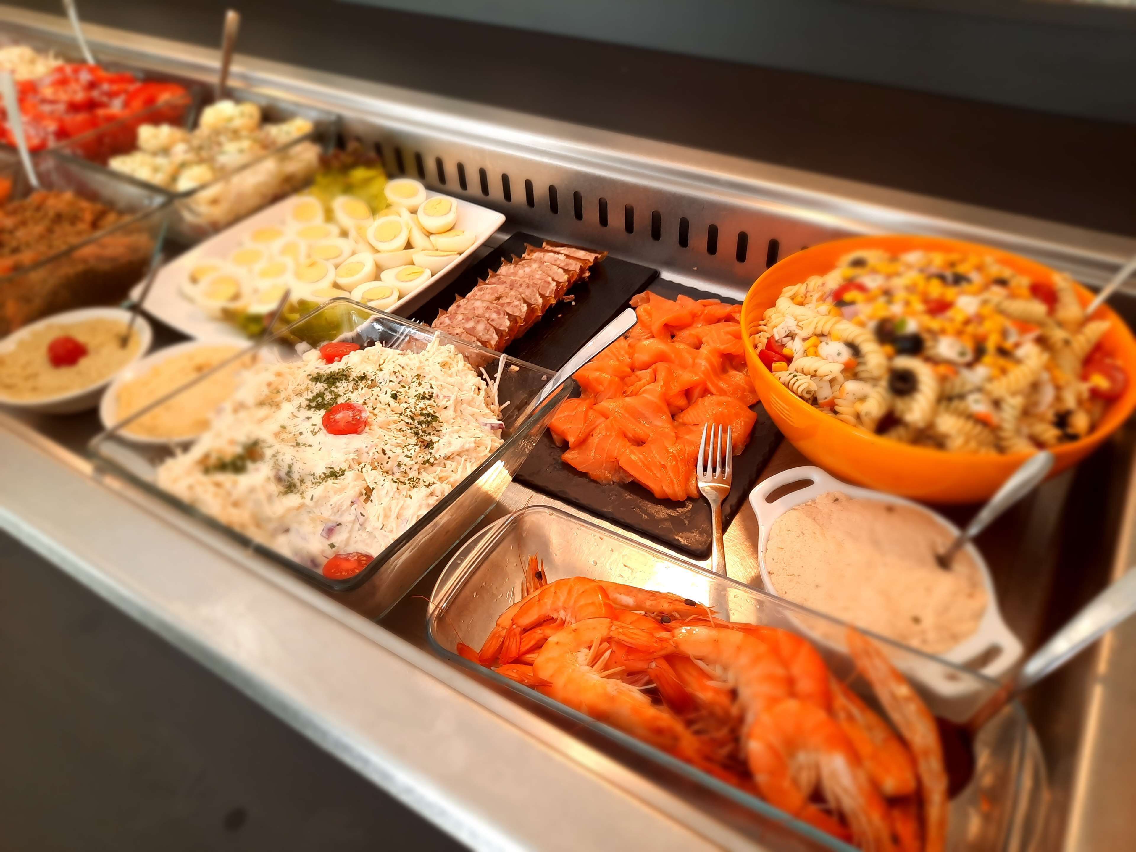 A buffet with various dishes including shrimp, pasta, and salads.