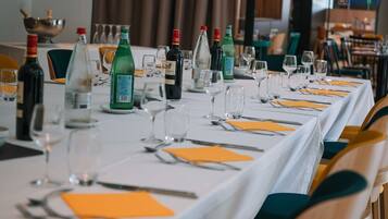 A restaurant table set with wine bottles, glasses, and cutlery.