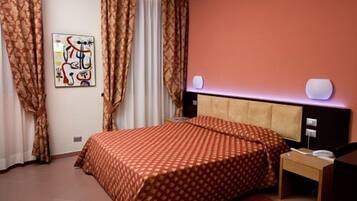 Ein Schlafzimmer mit einem Bett, Vorhängen, einem Wandbild und einem Nachttisch.