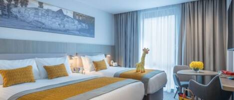 A hotel room with two beds, a desk, and a chair.